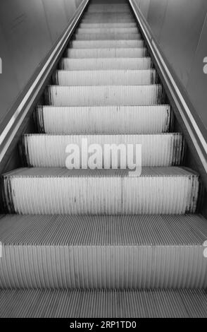 Lange Rolltreppen im Einkaufszentrum, ohne Personen in Schwarz und weiß Stockfoto