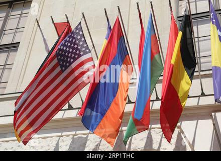 Viele bunte Flaggen verschiedener Weltnationen und amerikanische Flagge, die vor dem Regierungsgebäude hing, ohne Menschen Stockfoto