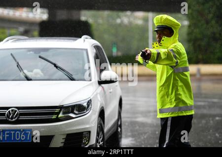 (180724) -- TIANJIN, 24. Juli 2018 (Xinhua) -- Ein Polizist leitet den Verkehr im Bezirk Nankai der nordchinesischen Gemeinde Tianjin, 24. Juli 2018. Schwere Regenfälle, die von Taifun Ampil zwischen Montag und Dienstagmorgen auf Peking und die angrenzenden Gebiete gebracht wurden, sagte das National Meteorological Center (NMC). (Xinhua/Li ran) (hxy) CHINA-TYPHOON AMPIL-RAINFALL (CN) PUBLICATIONxNOTxINxCHN Stockfoto