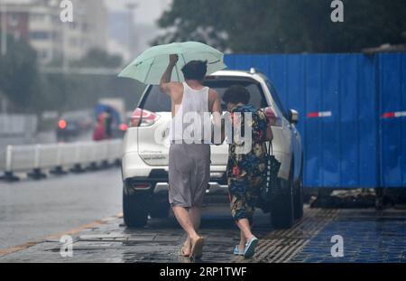 (180724) -- TIANJIN, 24. Juli 2018 (Xinhua) -- Fußgänger laufen im Regen im Bezirk Nankai der nordchinesischen Gemeinde Tianjin, 24. Juli 2018. Schwere Regenfälle, die von Taifun Ampil zwischen Montag und Dienstagmorgen auf Peking und die angrenzenden Gebiete gebracht wurden, sagte das National Meteorological Center (NMC). (Xinhua/Li ran) (hxy) CHINA-TYPHOON AMPIL-RAINFALL (CN) PUBLICATIONxNOTxINxCHN Stockfoto