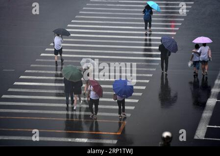 (180724) -- TIANJIN, 24. Juli 2018 (Xinhua) -- Fußgänger laufen im Regen im Bezirk Nankai der nordchinesischen Gemeinde Tianjin, 24. Juli 2018. Schwere Regenfälle, die von Taifun Ampil zwischen Montag und Dienstagmorgen auf Peking und die angrenzenden Gebiete gebracht wurden, sagte das National Meteorological Center (NMC). (Xinhua/Li ran) (hxy) CHINA-TYPHOON AMPIL-RAINFALL (CN) PUBLICATIONxNOTxINxCHN Stockfoto