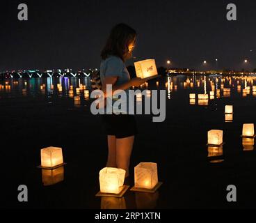 (180805) -- WASHINGTON, 5. Aug. 2018 -- Ein Mädchen hält eine Wasserlaterne während eines Wasserlaternenfestivals im National Habor in Maryland, USA, 4. Aug. 2018. Laternen wurden am Samstag zum Water Lantern Festival auf dem Potomac River in Wasser gesetzt, wodurch eine spektakuläre und glitzernde Lichtanzeige entstand. ) U.S.-MARYLAND-WATER LATERNE FESTIVAL LiuxJie PUBLICATIONxNOTxINxCHN Stockfoto