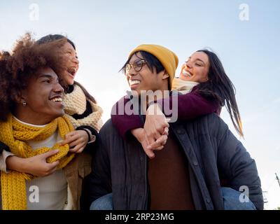 Gruppe von multiethnischen Freunden in Winterkleidung, die Spaß in einer Stadt haben. Gemeinschaft, Freundschaft, Winter Stockfoto