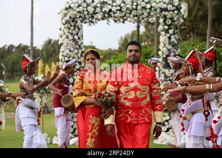 (180817) -- COLOMBO, 17. August 2018 -- Ein Sri-lankischer Paarspaziergang während der massenhaften Hochzeitszeremonie in Negombo, Sir Lanka, am 17. August 2018. 19 Paare aus China und Sri Lanka wurden hier am Donnerstag bei einer Massenhochzeit in Negombo vermählt, wodurch die Position der Insel als ideales Hochzeitsziel gestärkt wurde. UM MIT 19 chinesischen, Sri-lankischen Paaren zu GEHEN, die bei einer Massenhochzeit in Sri Lanka vermählt wurden) (Qxy) SRI LANKA-NEGOMBO-MASSENHOCHZEIT ZhuxRuiqing PUBLICATIONxNOTxINxCHN Stockfoto