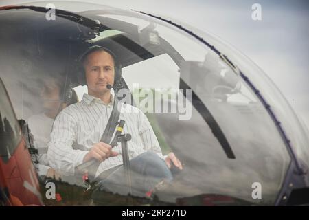 Taastrup, Dänemark, 11. August 2023: Mann im Cockpit eines Hubschraubers Stockfoto
