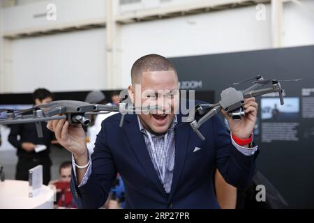 (180823) -- NEW YORK, 23. August 2018 -- A man posiert mit den neu veröffentlichten DJI Mavic 2 Pro (R) und Mavic 2 Zoom Drohnen während der Startzeremonie in New York, USA, 23. August 2018. Der chinesische Drohnenhersteller DJI hat am Donnerstag in New York seine neue Mavic Drohnen-Reihe, den Mavic 2 Pro und den Mavic 2 Zoom, vorgestellt. Mavic 2 Pro verfügt über eine integrierte Hasselblad-Kamera, und Mavic 2 Zoom ist eine klappbare Drohne mit optischem Zoom. ) U.S.-NEW YORK-DJI-DRONE-RELEASE LIXMUZI PUBLICATIONXNOTXINXCHN Stockfoto