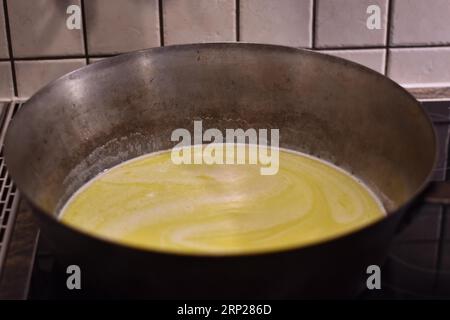 Zubereitung von Dampfnudeln, Butter in rustikaler alter Dampfnudelpfanne, typisch bayerische Küche, Deutschland Stockfoto