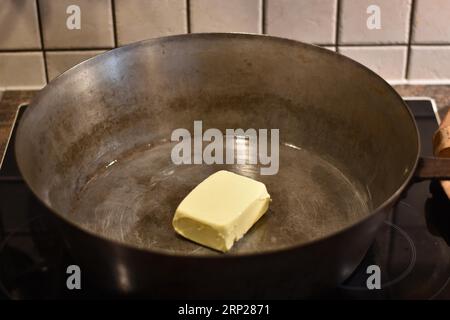 Zubereitung von Dampfnudeln, Butter in rustikaler alter Dampfnudelpfanne, typisch bayerische Küche, Deutschland Stockfoto