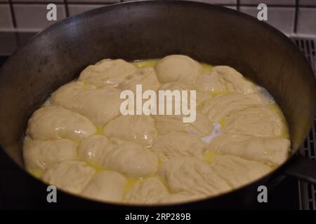 Zubereitung von Dampfnudeln in rustikaler alter Dampfnudelpfanne, typisch bayerische Küche, Deutschland Stockfoto