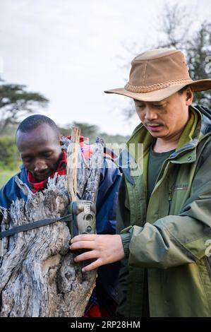 (180824) -- -MAASAI MARA, 24. August 2018 -- der chinesische Tierschützer Zhuo Qiang (R) stellt eine Infrarot-Kamera auf der Ol Kinyei Conservancy in Maasai Mara, Kenia, 9. Juli 2018 auf. Der Gründer und Vorsitzende des Mara Conservation Fund (MCF), Zhuo Qiang, ein 45-jähriger Chinese, hat im weltberühmten Maasai Mara-Ökosystem Pionierarbeit bei herausragenden Naturschutzprojekten geleistet. Ol Kinyei gehört zu den Konservativen, die von seinen Aktivitäten profitieren. Um ihn herum hat er drei Löwen-Proof-Boas gebaut, die den Wildtierkonflikt mit den benachbarten Gemeinden verhindern. Er wurde offiziell als Sohn von Th adoptiert Stockfoto