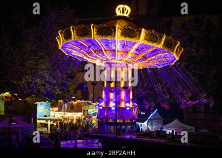 Die bunten Lichter des Karussells auf dem Mainfest leuchten am Abend. Das Mainfest auf dem Mainkai, Fahrtor und Roemerberg ist eines der Frankfurter Stockfoto