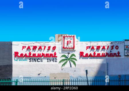 historisches Paraiso-Restaurantgebäude, gelegen in der 115 W 3rd St in Los Angeles, Kalifornien, mit verwitterter weißer Fassade und Vintage roten Neon-Schildern Stockfoto