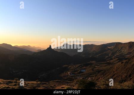 Blick auf Roque Nublo auf Gran Canaria mit der Silhouette des Teide-Berges im Hintergrund und einer Meereswolke. Sonnenuntergang auf Gran Canaria. Roque Nublo Stockfoto