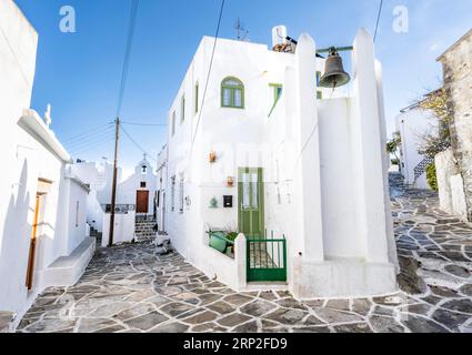 Weiße kykladische Häuser mit grünen Fenstern und Türen, kleine griechisch-orthodoxe Kirche hinten, malerische Gassen des Dorfes Lefkes, Paros Stockfoto