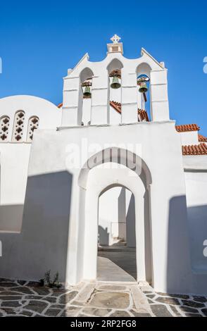 Bogengang mit Glocken der Kapelle von Agios Antonios und griechisch-orthodoxe Kirche von Metamorfosi Sotiros, Gassen des Dorfes Marpissa, Paros Stockfoto