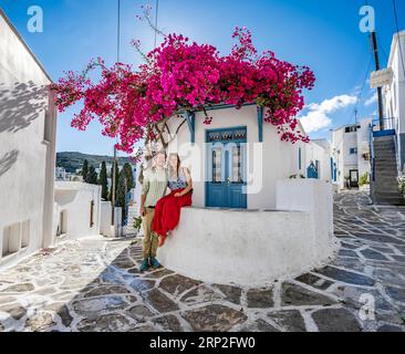 Verliebtes junges Paar, weißes Kykladen-Haus mit blauer Tür und rosa Bougainvillea, mit Sonnenstern, malerische Gassen des Dorfes Lefkes, Paros Stockfoto