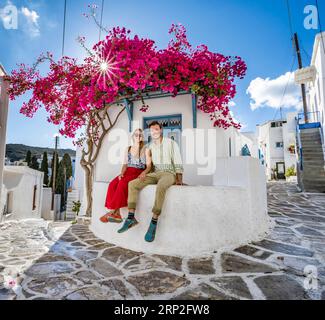 Verliebtes junges Paar, weißes Kykladen-Haus mit blauer Tür und rosa Bougainvillea, mit Sonnenstern, malerische Gassen des Dorfes Lefkes, Paros Stockfoto