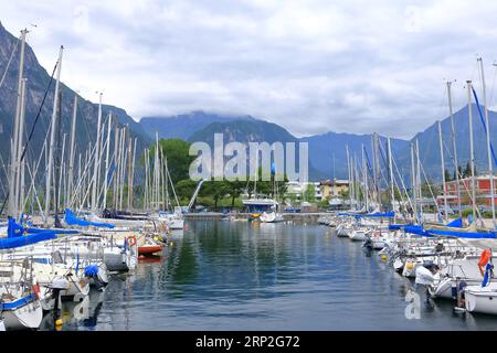 Mai 19 2023 - Riva del Garda in Italien: Menschen am Hafen der Stadt an einem bewölkten Tag Stockfoto
