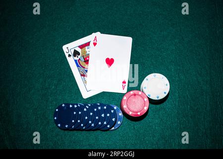 Jack Spade Heart Ass Karte mit Casino Chips Stapel grünen Pokertisch Stockfoto