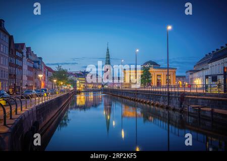 Skyline des Kopenhagener Kanals und Slotsholmen mit Nikolaj Kunsthal-Turm bei Nacht - Kopenhagen, Dänemark Stockfoto