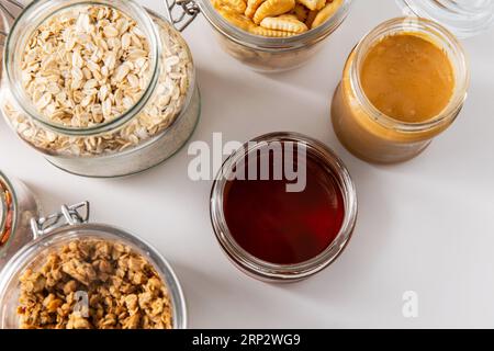 Gläser mit Hafer, Keksen, Erdnussbutter und Honig Stockfoto