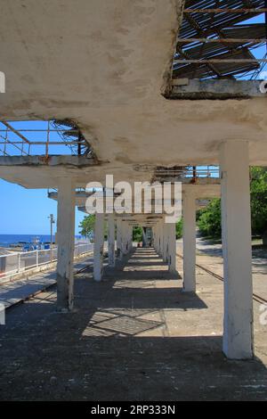 Das Foto wurde in der Stadt Odessa an einem öffentlichen Strand gemacht. Das Foto zeigt ein altes Gebäude aus der Zeit der Sowjetunion, das vor den s schützt Stockfoto