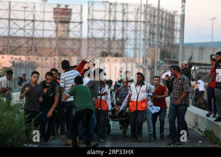 (180918) -- GAZA, 18. September 2018 () -- palästinensische Sanitäter tragen einen Verwundeten bei Zusammenstößen mit israelischen Truppen nach einem Protest auf dem Erez-Grenzübergang in der Nähe der Grenze zu Israel im nördlichen Gazastreifen am 18. September 2018. Zwei Palästinenser wurden getötet und mehr als 30 verwundet am Dienstagabend durch israelische Truppen Schüsse im nördlichen Gazastreifen, in der Nähe der Grenze zu Israel, sagten Mediziner. () MIDEAST-GAZA-KONFLIKTE Xinhua PUBLICATIONxNOTxINxCHN Stockfoto