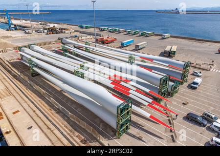 Porto Torres, Sardinien, Italien. Industriegebiet. Autos und Rotorblätter von Windkraftanlagen warten auf das Verladen auf dem Schiff. Stockfoto