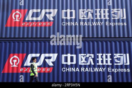 (181006) -- PEKING, 6. Oktober 2018 -- Ein Mitarbeiter läuft am Intermodal-Terminal Duisburg in Duisburg, Westdeutschland, 16. April 2018 an Containern des China Railway Express vorbei. ) Xinhua-Schlagzeilen: Für die B&R-Initiative bedeutet die neue Konnektivitätsstrategie der EU mehr Zusammenarbeit als Wettbewerb LuoxHuanhuan PUBLICATIONxNOTxINxCHN Stockfoto