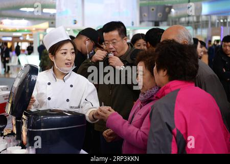 (181010) -- HARBIN, 10. Oktober 2018 -- Menschen schmecken Reisgerichte während des ersten Internationalen Reisfestes Chinas in Harbin, Hauptstadt der nordöstlichen Provinz Heilongjiang, 10. Oktober 2018. Das Festival, an dem mehr als 200 Aussteller teilnahmen, startete hier am Mittwoch. ) (Yxb) CHINA-HARBIN-RICE FESTIVAL(CN) WangxKai PUBLICATIONxNOTxINxCHN Stockfoto