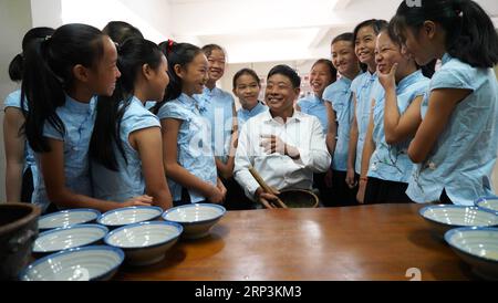 (181010) -- NANCHANG, 10. Oktober 2018 -- Liao Yongchuan, repräsentativer Erbe von Hakka Lei Cha, einer traditionellen Methode zur Herstellung von Brei auf Teebasis, stellt den Schülern der Quannan No.4 Primary School im Quannan County, ostchinesische Provinz Jiangxi, 10. Oktober 2018 den Herstellungsprozess vor. ) (HXY) CHINA-JIANGXI-IMMATERIBLE CULTURAL HERITAGE-HAKKA LEI CHA (CN) HUXCHENHUAN PUBLICATIONXNOTXINXCHN Stockfoto