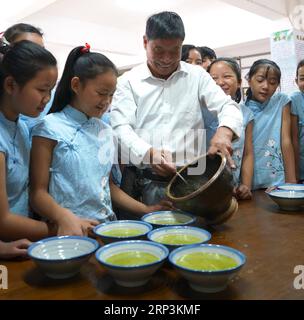 (181010) -- NANCHANG, 10. Oktober 2018 -- Liao Yongchuan, repräsentativer Erbe von Hakka Lei Cha, einer traditionellen Methode zur Herstellung von Brei auf Teebasis, führt den Prozess für Schüler der Quannan No.4 Primary School im Quannan County, Provinz Jiangxi, 10. Oktober 2018 durch. ) (HXY) CHINA-JIANGXI-IMMATERIBLE CULTURAL HERITAGE-HAKKA LEI CHA (CN) HUXCHENHUAN PUBLICATIONXNOTXINXCHN Stockfoto