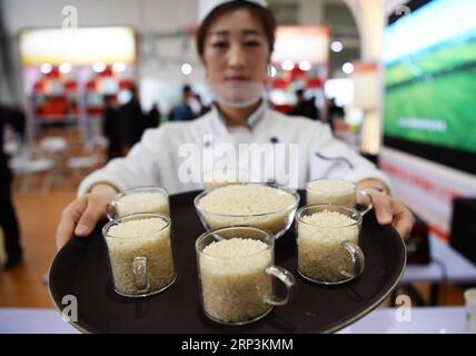 (181010) -- HARBIN, 10. Oktober 2018 -- ein Aussteller zeigt Reis während des ersten Internationalen Reisfestes Chinas in Harbin, Hauptstadt der nordöstlichen Provinz Heilongjiang, 10. Oktober 2018. Das Festival, an dem mehr als 200 Aussteller teilnahmen, startete hier am Mittwoch. ) (Yxb) CHINA-HARBIN-RICE FESTIVAL(CN) WangxKai PUBLICATIONxNOTxINxCHN Stockfoto