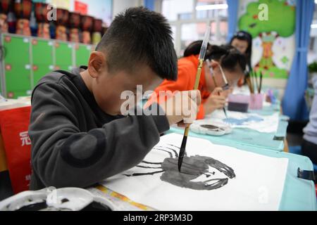 (181010) -- HARBIN, 10. Oktober 2018 -- Schüler lernen chinesische Malerei an einer Grundschule in Harbin, Provinz Heilongjiang im Nordosten Chinas, 10. Oktober 2018. Seit 2017 hat die Regierung von Harbin ein Service-Programm ins Leben gerufen, bei dem Schüler von mehr als 240 Grundschulen in der Schule bleiben und traditionelle Kulturen lernen können, die von Schulen angeboten werden, während sie darauf warten, dass ihre Eltern sie abholen. ) (Gxn) CHINA-HEILONGJIANG-HARBIN-AFTER-SCHOOL SERVICE (CN) WangxKai PUBLICATIONxNOTxINxCHN Stockfoto