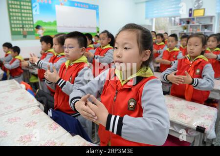 (181010) -- HARBIN, 10. Oktober 2018 -- Schüler singen ein Lied mit Gebärdensprache an einer Grundschule in Harbin, nordöstliche Provinz Heilongjiang, 10. Oktober 2018. Seit 2017 hat die Regierung von Harbin ein Service-Programm ins Leben gerufen, bei dem Schüler von mehr als 240 Grundschulen in der Schule bleiben und traditionelle Kulturen lernen können, die von Schulen angeboten werden, während sie darauf warten, dass ihre Eltern sie abholen. ) (Gxn) CHINA-HEILONGJIANG-HARBIN-AFTER-SCHOOL SERVICE (CN) WangxKai PUBLICATIONxNOTxINxCHN Stockfoto