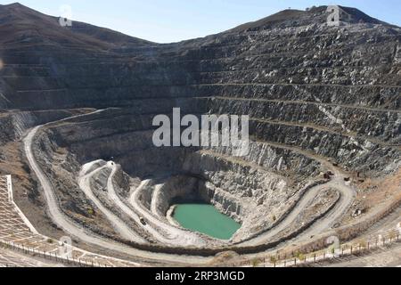 (181011) -- ÜRÜMQI, 11. Oktober 2018 -- Foto aufgenommen am 10. Oktober 2018 zeigt die Landschaft eines Minenkraters im Keketuohai UNESCO Global Geopark in der autonomen Region Xinjiang Uygur im Nordwesten Chinas. Xinjiang eröffnete am Mittwoch offiziell seinen ersten Geopark in Keketuohai. Der Park liegt südlich der Altay Mountains und an der Quelle des Irtysh River und erstreckt sich über mehr als 2.300 Quadratkilometer. Besucher können atemberaubende Ausblicke genießen, darunter den Irtysh Grand Canyon, einen riesigen Minenkrater, Seen, Berge, einen Wasserfall, Fossilien und Flüsse. Die UNESCO kündigte acht neue globale Geoparks in Ma an Stockfoto