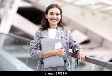 Happy Young Business Woman Holding Laptop And Smartphone At Modern Airport Stockfoto