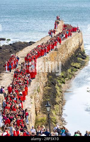 St. Andrews, Fife, Schottland. September 2023. Neue Studenten an der Universität von St. Andrews in roten Gewändern nehmen am traditionellen Pier Walk entlang der Hafenmauern von St. Andrews vor Beginn des neuen akademischen Jahres Teil. Das Martinmas Semester © Richard Newton / Alamy Live News Stockfoto