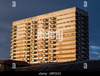 Der Sonnenuntergang erstrahlt im Inkerman House, einem heruntergekommenen 12-stöckigen Turmblock über dem Newtown Shopping Centre im Newtown-Viertel von Aston, Birmingham, Großbritannien. Stockfoto