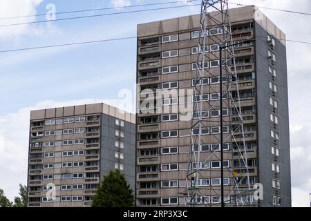 Zwei verlassene und verlassene Turmblöcke mit einem Pylon davor, die für den Abriss vorgesehen sind, in Druids Heath, Birmingham, England 2023. Stockfoto