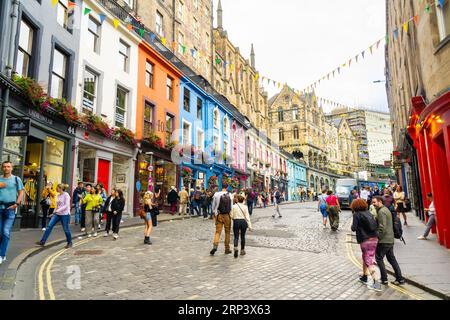 Edinburgh, Schottland, Großbritannien - 18. August 2023: Touristen besichtigen die berühmte Victoria Street mit ihren bunten Häusern an einem Sommertag. Stockfoto