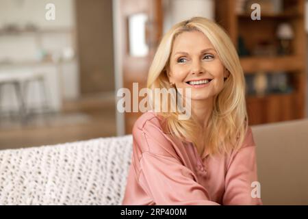 Porträt Der Schönen Blonden Reifen Dame, Die Ins Haus Schaut Stockfoto