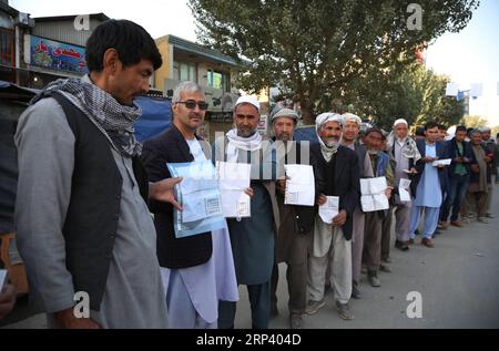 (181020) -- KABUL, 20. Oktober 2018 -- afghanische Wähler zeigen ihre Personalausweise, während sie warten, um ihre Stimmzettel in einem Wahlzentrum während der Parlamentswahlen in Kabul, der Hauptstadt Afghanistans, am 20. Oktober 2018 abzugeben. Millionen afghanischer Wähler haben am Samstag ihre Stimmzettel zu lang verzögerten Parlamentswahlen in dem von Militanz geplagten Land abgegeben, während Berichte über Sicherheitsbedrohungen und Unregelmäßigkeiten vorliegen. )(zhf) AFGHANISTAN-KABUL-PARLAMENTSWAHLEN RahmatxAlizadah PUBLICATIONxNOTxINxCHN Stockfoto