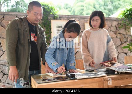 (181021) -- HUZHOU, 21. Oktober 2018 -- Touristen machen Holzschnitte im Dorf Longshan im Bezirk Wuxing in Huzhou, Ostchinesische Provinz Zhejiang, 21. Oktober 2018. In den letzten Jahren wurden große Anstrengungen im Bereich Infrastrukturbau und Umweltschutz des Bezirks Wuxing unternommen, um den ländlichen Tourismus anzukurbeln. ) (Hxy) CHINA-ZHEJIANG-HUZHOU-TOURISM (CN) HuangxZongzhi PUBLICATIONxNOTxINxCHN Stockfoto