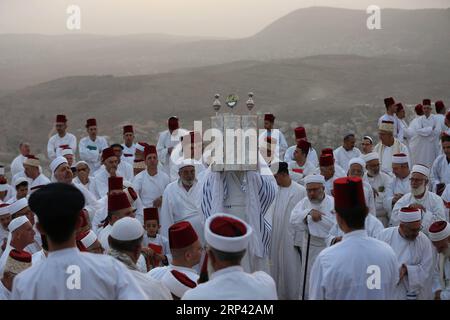 (181023) -- NABLUS, 23. Oktober 2018 -- Ein Priester der alten samaritanischen Gemeinde hält eine Tora-Rolle während einer traditionellen Pilgerfahrt auf dem Berg Gerizim in der Nähe der Westbank-Stadt Nablus, am 23. Oktober 2018. Sukkot ist ein festlicher Feiertag, in dem Stände gebaut werden, um an die Wohnungen zu erinnern, in denen die Hebräer während ihrer Reise durch die Wüste leben mussten. Ayman Nobani)(gj) MIDEAST-NABLUS-SAMARITANS-SUKKOT-PILGERREISE zhaoyue PUBLICATIONxNOTxINxCHN Stockfoto