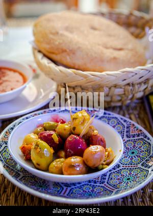 Marokkanisches Olivengericht und Brot auf dem Esstisch in einem Restaurant in Marrakesch Stockfoto