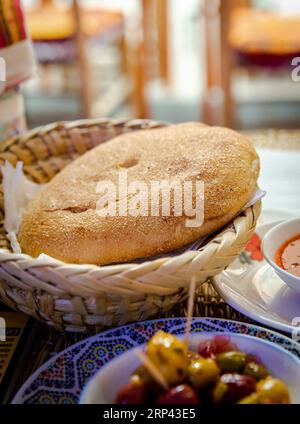 Marokkanisches Brot und Oliven auf dem Esstisch in einem Restaurant in Marrakesch Stockfoto