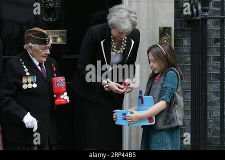 (181025) -- LONDON, 25. Oktober 2018 -- die britische Premierministerin Theresa May (C) kauft am 25. Oktober 2018 einen Mohn vor der 10 Downing Street in London, Großbritannien. Die Gedenktafel Mohn ist eine künstliche Blume, die seit 1921 verwendet wird, um Soldaten zu gedenken, die im Krieg gestorben sind. ) GROSSBRITANNIEN-LONDON-PREMIERMINISTER-GEDENKEN MOHNBLUME TIMXIRELAND PUBLICATIONXNOTXINXCHN Stockfoto
