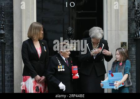 (181025) -- LONDON, 25. Oktober 2018 -- die britische Premierministerin Theresa May (2. R) legt am 25. Oktober 2018 mit Claire Rowcliffe (1. L), der Leiterin des Fundraising bei der Royal British Legion, der Veteranin Barbara Weatherill (2. L) aus dem Zweiten Weltkrieg und dem Fundraiser Poppy Railton vor der 10 Downing Street in London, Großbritannien, einen Mohnblumen am Revers fest. Die Gedenktafel Mohn ist eine künstliche Blume, die seit 1921 verwendet wird, um Soldaten zu gedenken, die im Krieg gestorben sind. ) GROSSBRITANNIEN-LONDON-PREMIERMINISTER-GEDENKEN MOHNBLUME TIMXIRELAND PUBLICATIONXNOTXINXCHN Stockfoto