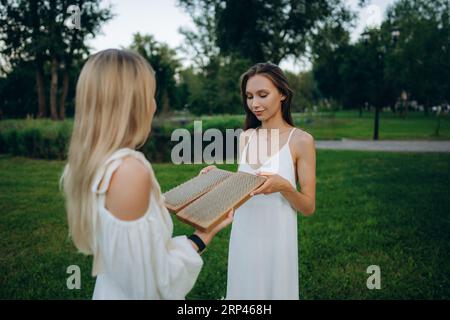 Mit Nägeln auf Brettern stehen. Junge Frauen, die Yoga und Therapie in der Natur praktizieren. Stockfoto